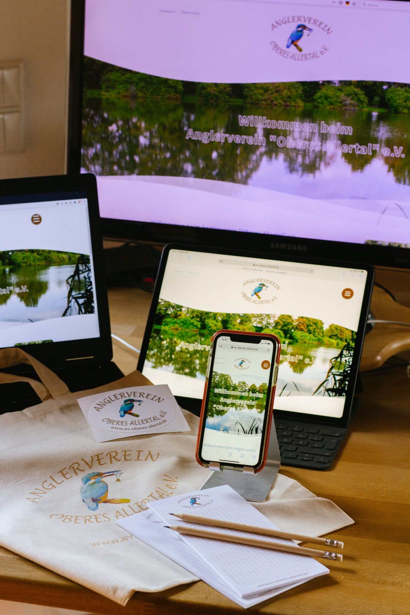 Website des Anglervereins mit Tasche und Aufkleber