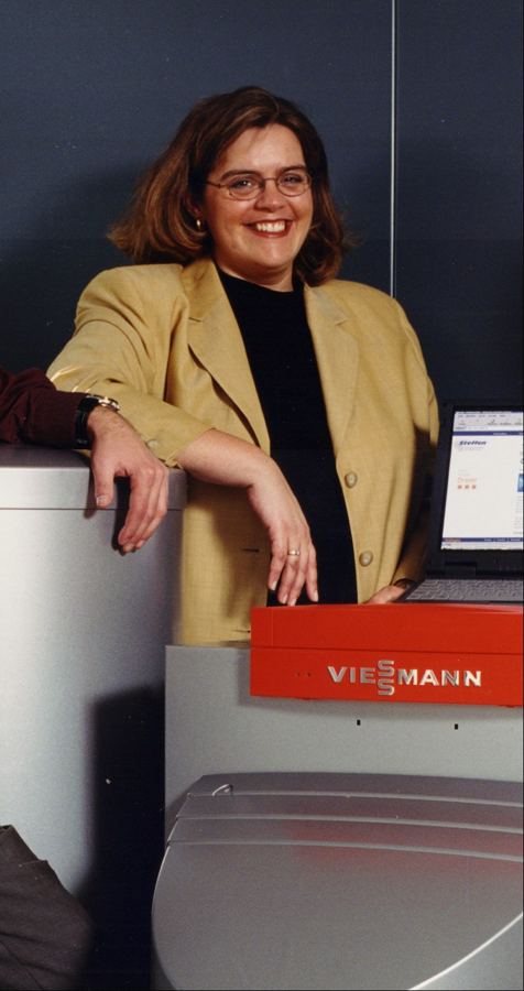 corinna-philippe-kueppers-heiztechnik Corinna Philippe-Küppers neben einem Heizkessel auf einer Veranstaltung