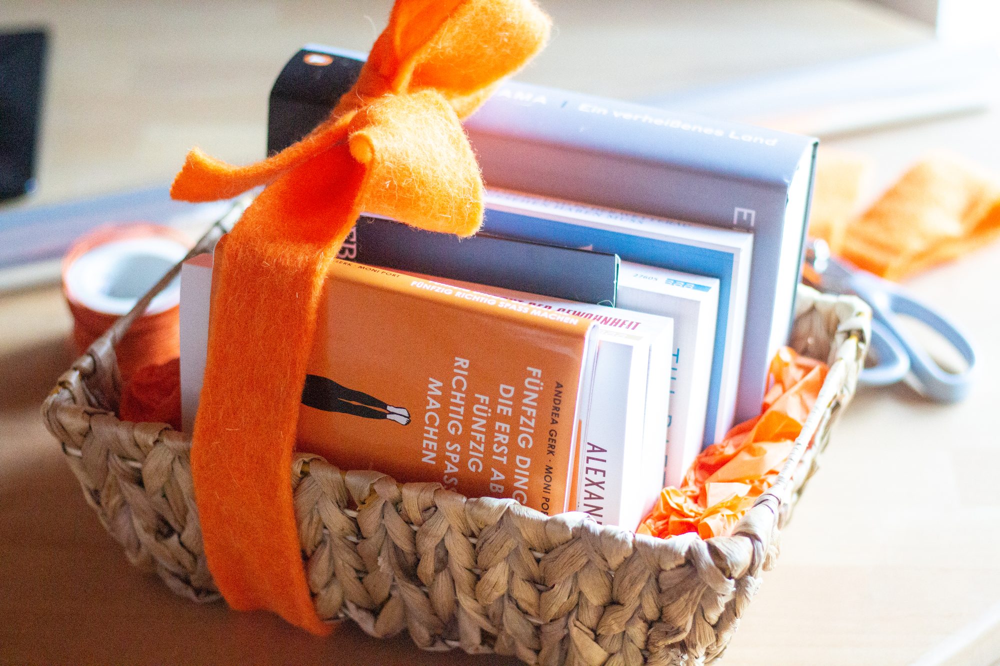 Geschenkkorb mit Büchern und oranger Schleife