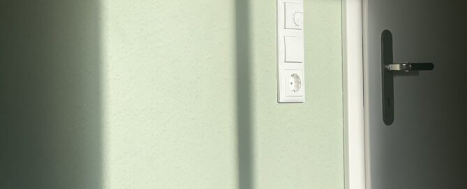 Sonnenlicht fällt durch ein Fenster auf eine helle Wand
